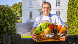 Chef Shane holding a basket of vegetables